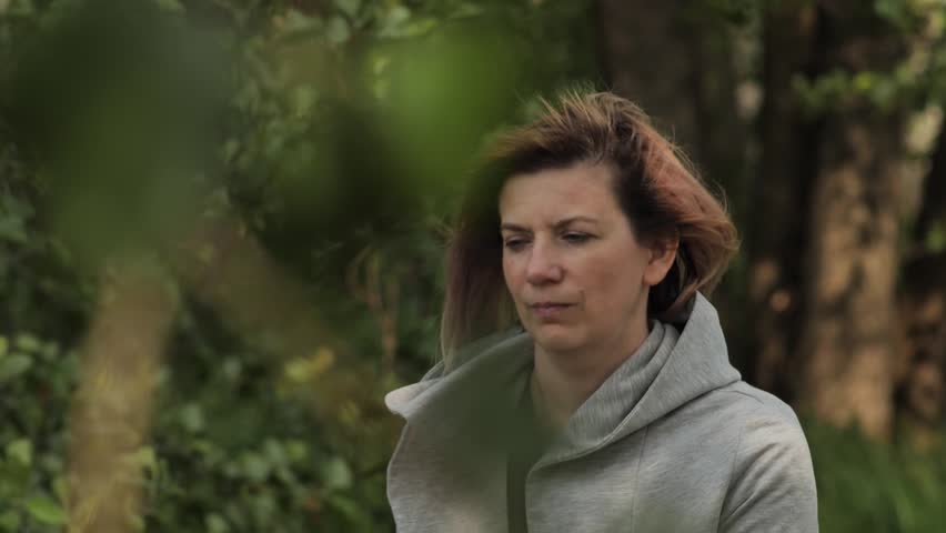 A depressed woman organizes her thoughts in nature. Close-up face of sad looking pensive woman suffering from loneliness depression. Unhappy vulnerable young woman dealing with stress | Shutterstock HD Video #1104515343