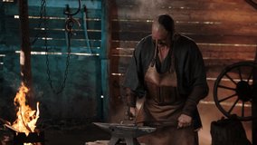 Blacksmith in the forge forges a horseshoe. Blacksmith makes iron products. Flames of fire in the Forge workshop. Ukrainian blacksmith. - Powered by Shutterstock - Get 15% off with code: PIKWIZARD15