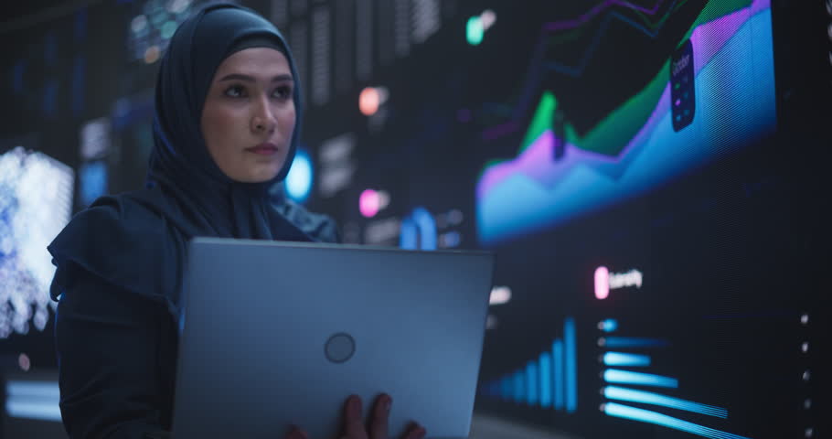 Portrait of Arab Female Working in an Advanced Technology Company. Woman Wearing a Hijab, Using Laptop Computer in a Room with an Artificial Intelligence Neural Network Software on a Digital Screen Royalty-Free Stock Footage #1104516849