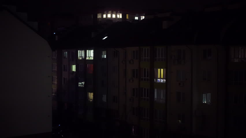 Urban residential building on dark night with flashing emergency lights reflecting on wall. Wide shot house in city in Ukraine during blackout Royalty-Free Stock Footage #1104518081