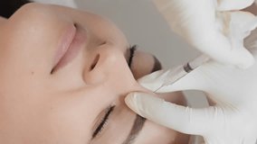 Instant youth where a professional cosmetologist uses botulinum to give a woman youth and natural beauty without wrinkles. Vertical video of the procedure in the cosmetology office