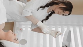 Video fragment of the magic of youth where a woman enjoys the procedure of botulinum therapy, at a cosmetologist, which fills her face with freshness and rejuvenation. Vertical video in beauty salon