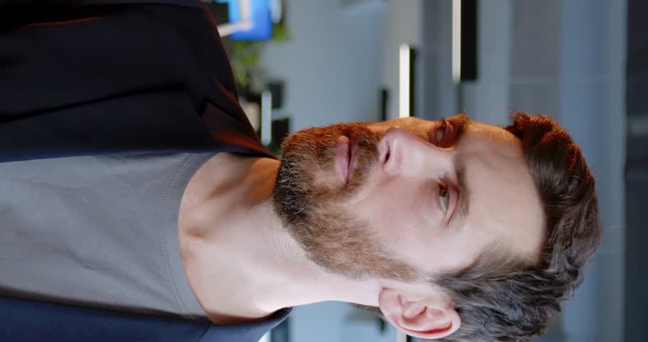 Vertical shoot. Portrait of middle-aged man. Man with green eyes turnes head and posing for camera. Man with red beard on blurred background. Attractive guy dressed up in business clothes.