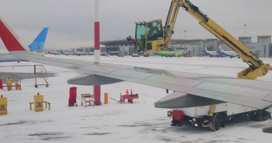 De icing of airplane before flight. Anti-icing is the application of chemicals that not only deice but also remain on a surface and continue to delay the reformation of ice Royalty-Free Stock Footage #1104520647