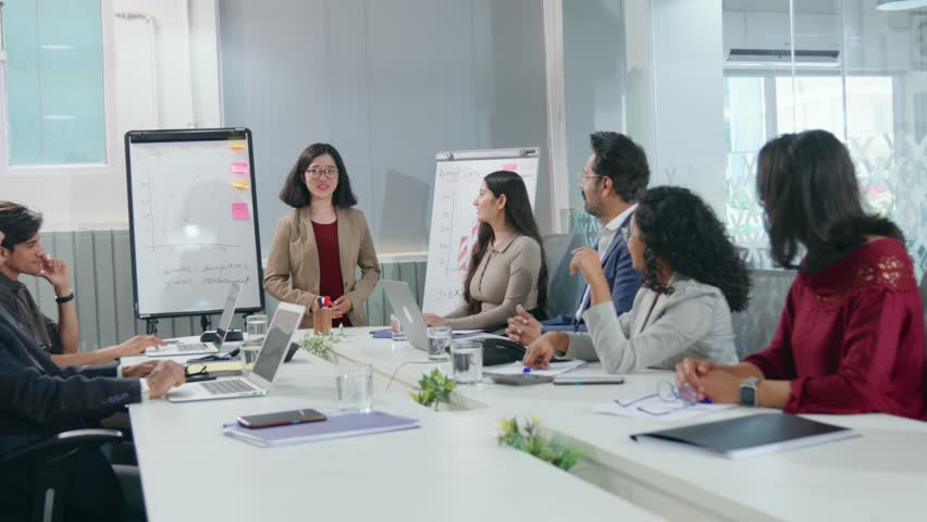 A young modern corporate Asian girl or female executive giving a presentation is appreciated or applauded by a diverse team of colleagues in a conference room meeting in a start-up office or business Royalty-Free Stock Footage #1104522503