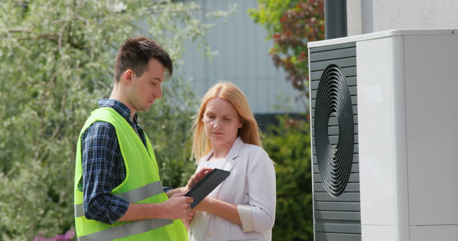 The specialist explains to the customer the principle of operation of the heat pump Royalty-Free Stock Footage #1104525039