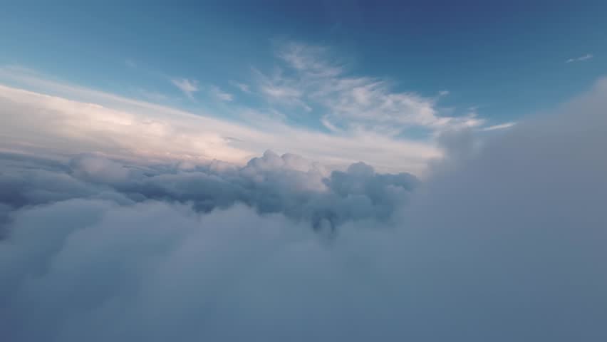 Scenic fluffy white clouds above and below the blue sky with sunbeams in the distance, sunset sky. 4k aerial cloudy landscape, drone Royalty-Free Stock Footage #1104529625