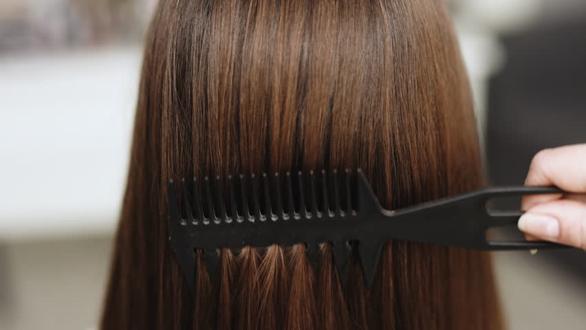 Close up of haircare, comb moves along beautiful healthy long flowing brown hair, texture. Healthy long smooth flowing brown hair | Shutterstock HD Video #1104530631