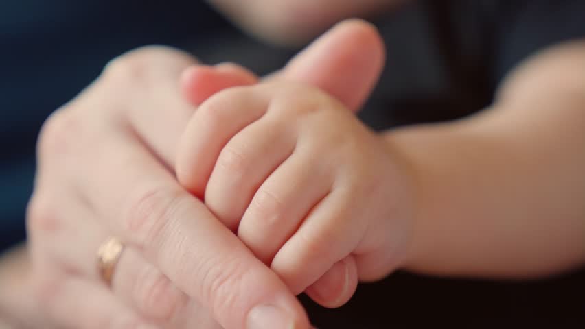 mother holds the hand of newborn. children hand. hospital takes care of happy family medicine concept. newborn baby holding mom hand close-up. mom takes dream care baby in the hospital Royalty-Free Stock Footage #1104533037