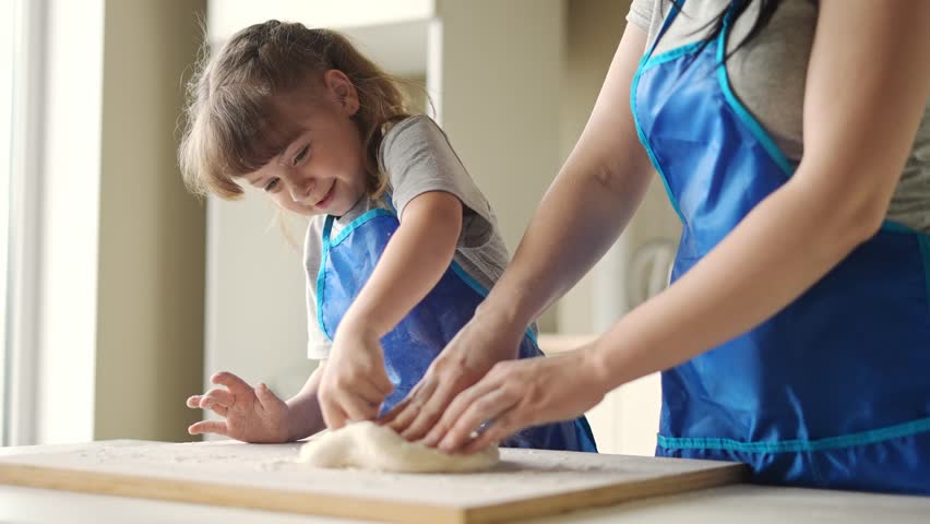 mother daughter preparing dough in kitchen. happy family cooking baking together. mother and bake small child preparing homemade cakes from flour and dough. happy family cooking at home Royalty-Free Stock Footage #1104533051