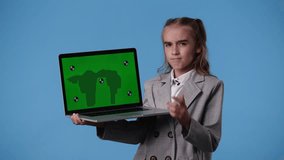 4k video of one girl using chroma key laptop and thinking over blue background.