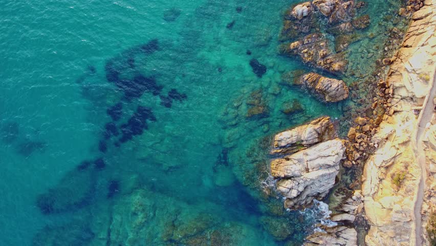 4K  Footage Aerial Top View Of Stones In Turquoise Sea Water Waves Wash The Rocks, Sandy Coast | Shutterstock HD Video #1104533547
