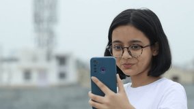 Indian Happy Girl child having a Video call with friends. Indian Happy She is a decent school girl marked by moral integrity, kindness, and goodwill. Cheerful conversation over the video phone call.