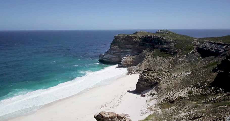 4K Aerial drone footage of Diaz Beach, Cape Town, South Africa. Rocky cliffs and Turquoise clean water with white sand beach in Cape Peninsula. Cape Point Nature Reserve with specific fauna and flora