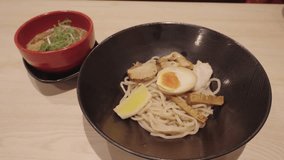 4k video, japanese cold ramen noodle on plate. Cold and delicious soup and cold noodles. Ramen with roast pork sliced and sauce in ceramic bowl. Healthy life style eating and Asian food concept.