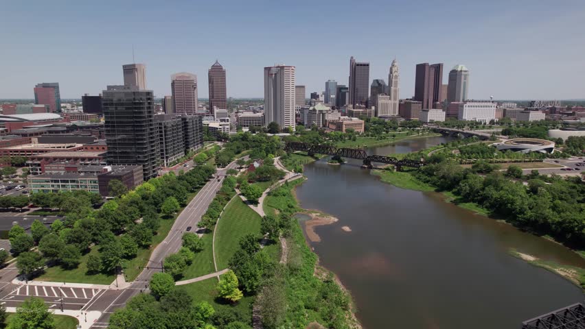 Helicopter aerial and drone establishing shot of Ohio state capital city of Columbus, OH with skyscrapers, skyline, and large buildings and apartments during a warm, summer day in  2023