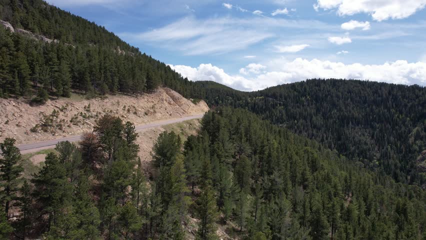 Panning over Casper Wyoming from Casper Mountain with beautiful clouds and green trees aerial 4k drone