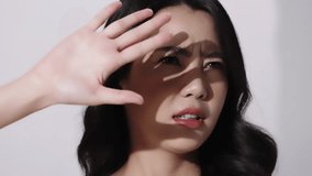 Beautiful young Asian woman with healthy perfect face skin covering face with palm from sun. Advertising of sunscreen skincare cosmetics. - Powered by Shutterstock - Get 15% off with code: PIKWIZARD15