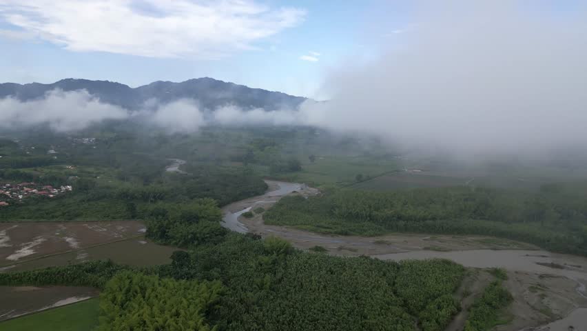 Drone flying in the clouds overlooking the skinny river