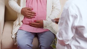 Close up shoulder shot of doctor examining pregnant woman belly using stethoscope at home - concept of Prenatal examination, Medical expertise and Maternal health care - Powered by Shutterstock - Get 15% off with code: PIKWIZARD15