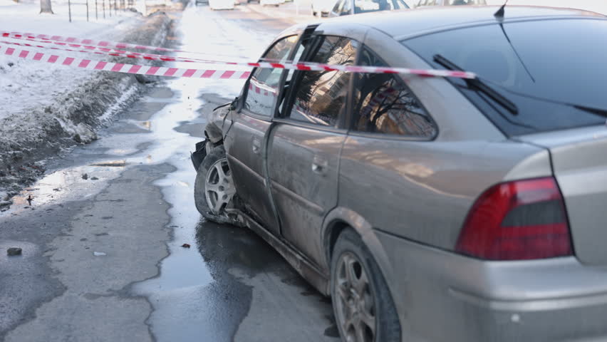 Car crash, car damage, accident scene. Wrecked car cordoned off with warning tape after collision, front section significantly damaged. Royalty-Free Stock Footage #1104572415