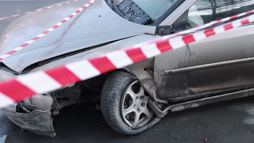 Car crash, car damage, accident scene. Car, with front heavily damaged in crash, enclosed by caution tape. Royalty-Free Stock Footage #1104572451