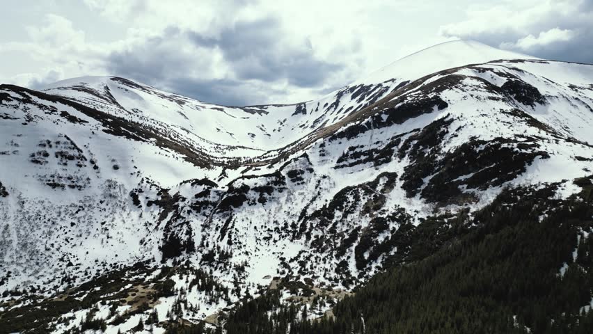 Flight over the Hoverla waterfall in the mountains, melting snow in the Carpathians, view of Hoverla from a drone