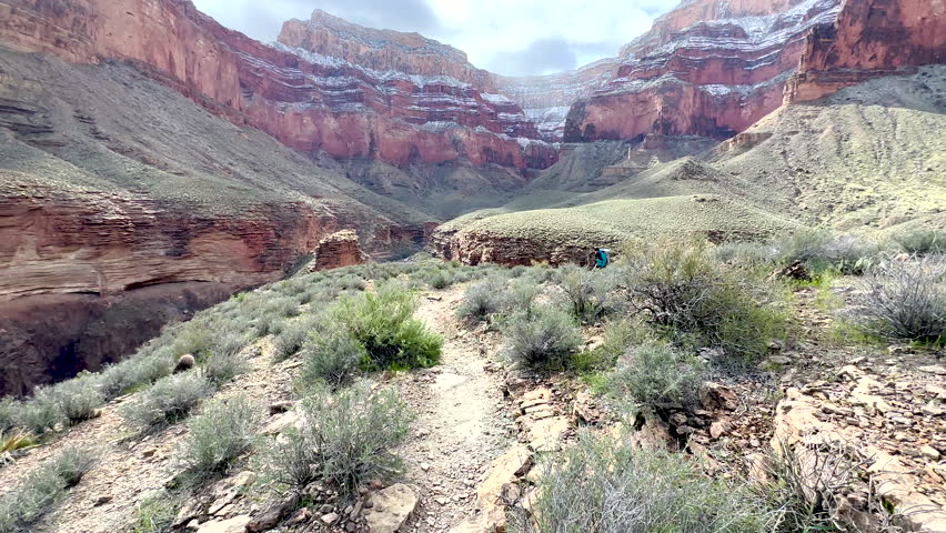 Hiker Climbs Hill And Pauses For Photo In Grand Canyon Along the Tonto Trail