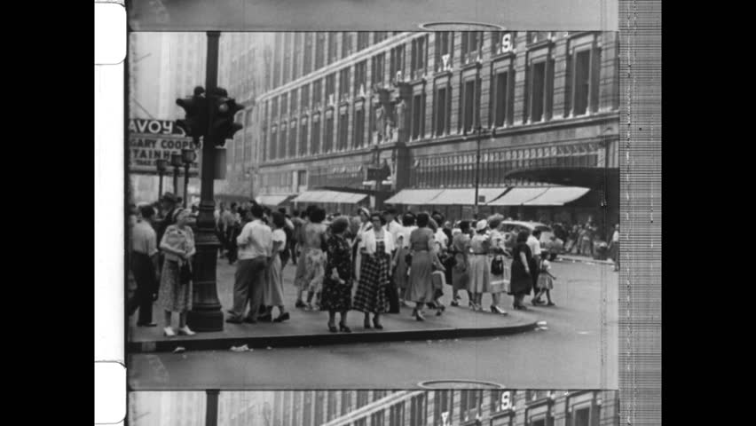 1947 New York, NY. Busy street scene in SOHO. City Buses, taxi cabs, and pedestrians cross crowed intersection. Iron facade building can be seen in background. 4K Overscan of vintage archival film 