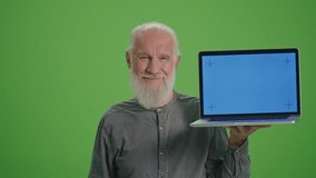 Green Screen. Portrait of a Smiling Old Man with a Laptop with Blue Screen and BTC Coin.Achievement Career Wealth, Cryptocurrency Investment, Mining.Bitcoin and the Future of Accumulated Pensions.