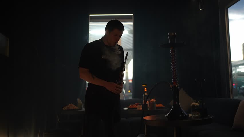A young man lights up a hookah