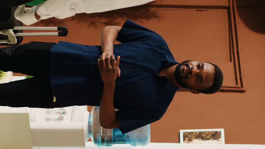 Vertical video Peole giving cash to bellhop in lobby, employee providing luxury service and carrying luggage trolley bags. Hotel guests paying money tip to bellboy in resort lounge area, vacation trip