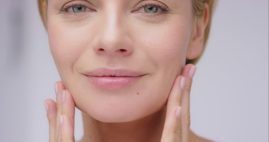 Woman touching face, beauty and skin with smile, antiaging cosmetic treatment and clean skincare. Natural cosmetics, happy female model and facial with portrait, dermatology and wellness with glow Royalty-Free Stock Footage #1104599063