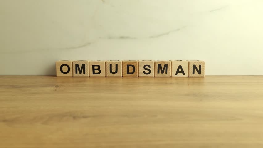 Ombudsman word from wooden blocks on desk Royalty-Free Stock Footage #1104602793
