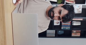 Vertical shoot. Vertical shoot. Portrait of bearded man with displeasure looking at screen of laptop. Adult male employee with work results. Happy office worker at workplace.