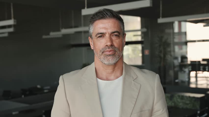 Smiling confident middle aged business man, mature older professional successful company ceo corporate leader wearing beige suit standing in modern office arms crossed looking at camera, portrait. Royalty-Free Stock Footage #1104603485
