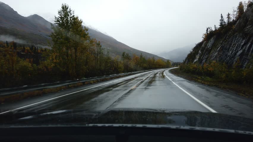 in the car to drive in heavy rain, wipers clean the windshield glass in alaska Royalty-Free Stock Footage #1104607595