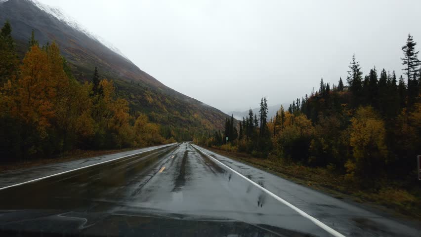 in the car to drive in heavy rain, wipers clean the windshield glass in alaska Royalty-Free Stock Footage #1104607625