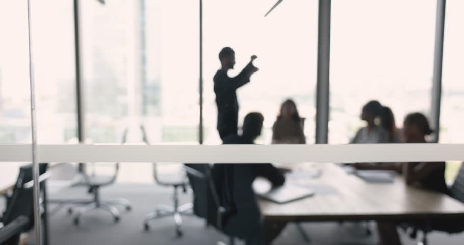 Silhouette of unknown businesspeople negotiate behind closed doors gathered in modern office conference room. Professional seminar, training event for corporate staff members, brainstorm and teamwork Royalty-Free Stock Footage #1104612373