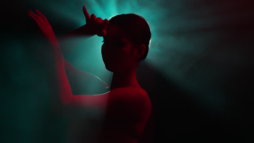 Solo performance by talented female performer, infusing stylish improvisation and classic ballet choreography in abstract modern dance. Dancer girl gracefully moves in light rays in slow motion