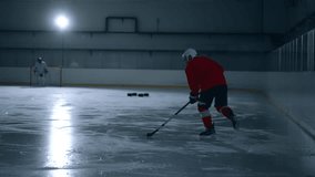 Action-packed video of a hockey player in red jersey training hard on the ice rink, showcasing his incredible skills and scoring a goal