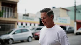 Pensive senior man standing in street with thoughtful expression. Person thinking deeply while in urban environment - Powered by Shutterstock - Get 15% off with code: PIKWIZARD15