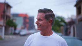Happy older man waving hello to neighbors while walking in street. A middle-age caucasian male person walks forward toward camera while greeting to friends around him - Powered by Shutterstock - Get 15% off with code: PIKWIZARD15