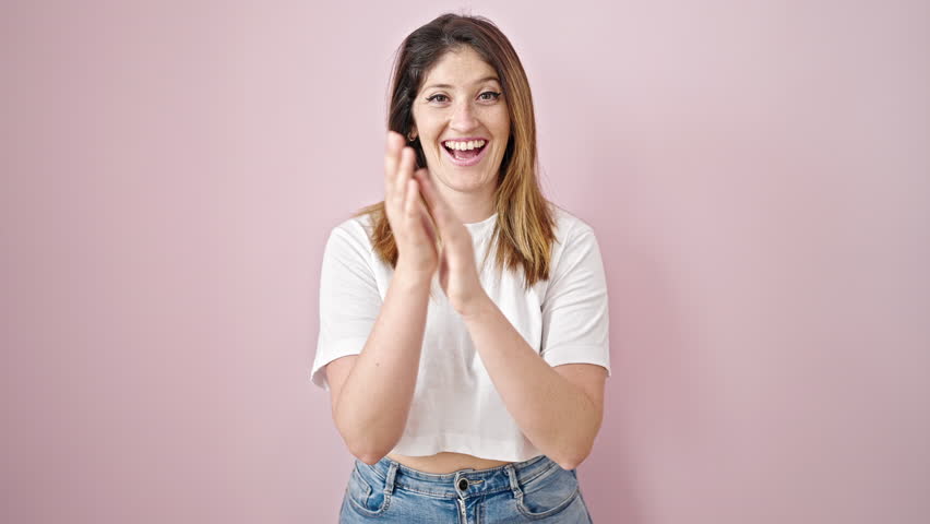 Young blonde woman smiling confident clapping applause over isolated pink background