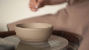 potter's wheel and earthenware. woman potter works on a potter's wheel. real time video. close-up. High-quality Full HD video recording