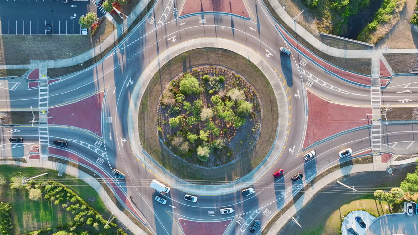 Traffic circle on american road with driving cars. Overhead view of US roundabout intersection Royalty-Free Stock Footage #1104620949