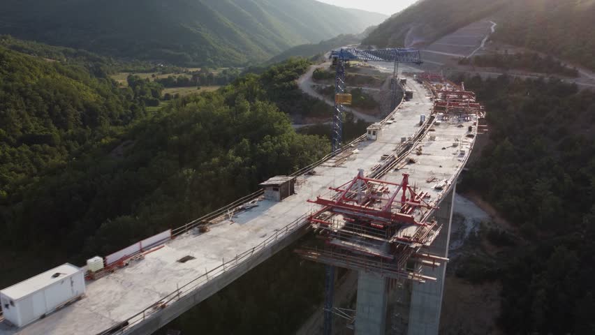 Highway bridge under construction. Aerial view of nes road. Freeway being built on a mountain terrain. Royalty-Free Stock Footage #1104621977