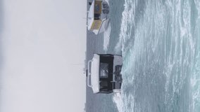 Vertical video. Rear view of ferries full of tourists departing from pier near Velana International Airport