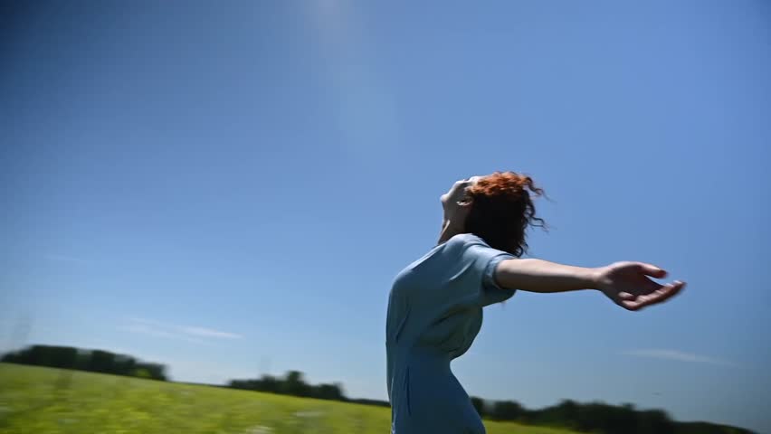 Caucasian young woman in a blue dress dances in a field. Video 360 degrees. Slow motion. 