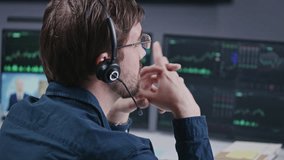Close up shot of male financial analyst in headset working in bank office. Multi-monitor computer with real-time stocks, exchange market charts, graphs and TV news. Analytics, cryptocurrency trading. - Powered by Shutterstock - Get 15% off with code: PIKWIZARD15